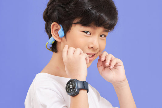 Child wearing myFirst open ear headphones kids edition, paired with a safe smartwatch for video calling and music.