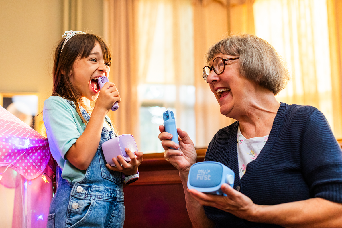 A granddaughter and grandma using the myFirst Voice 2 speakers to sing karaoke together and having a lot of fun.