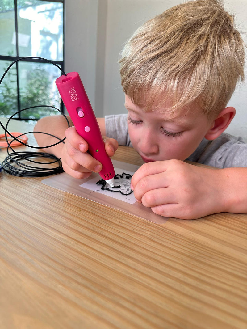 A kid using a pink 3D printing pen at his desk