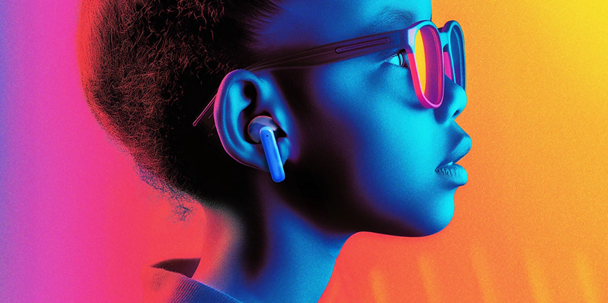 Child wearing myFirst CareBuds kids wireless earbuds and sunglasses under colorful neon lights.
